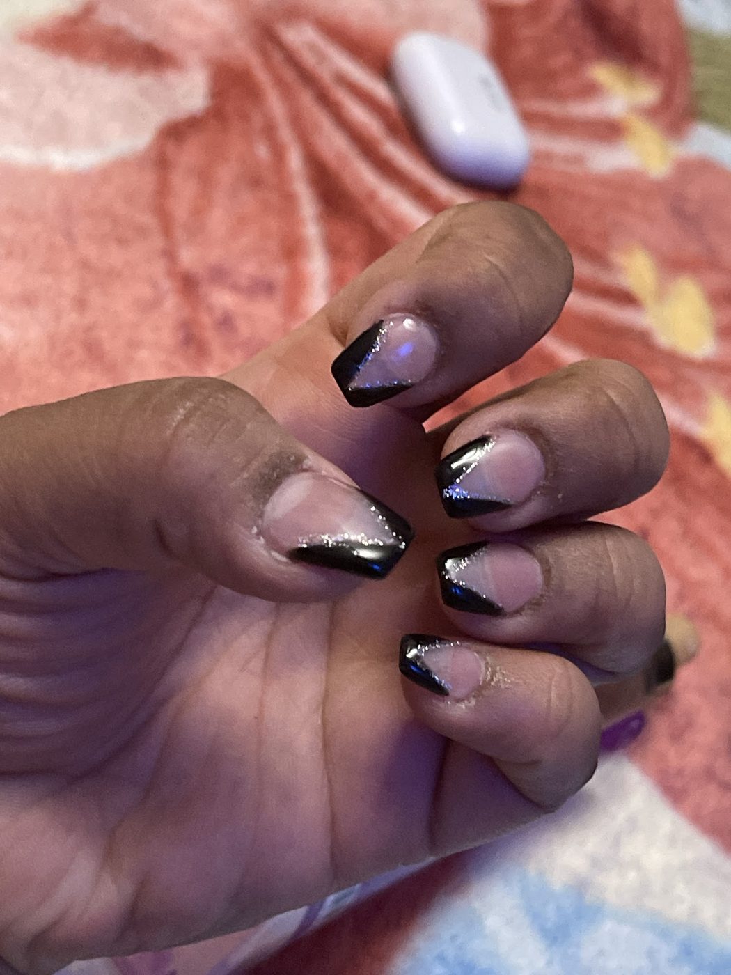 Square nails with black V French tips and a silver glitter line.